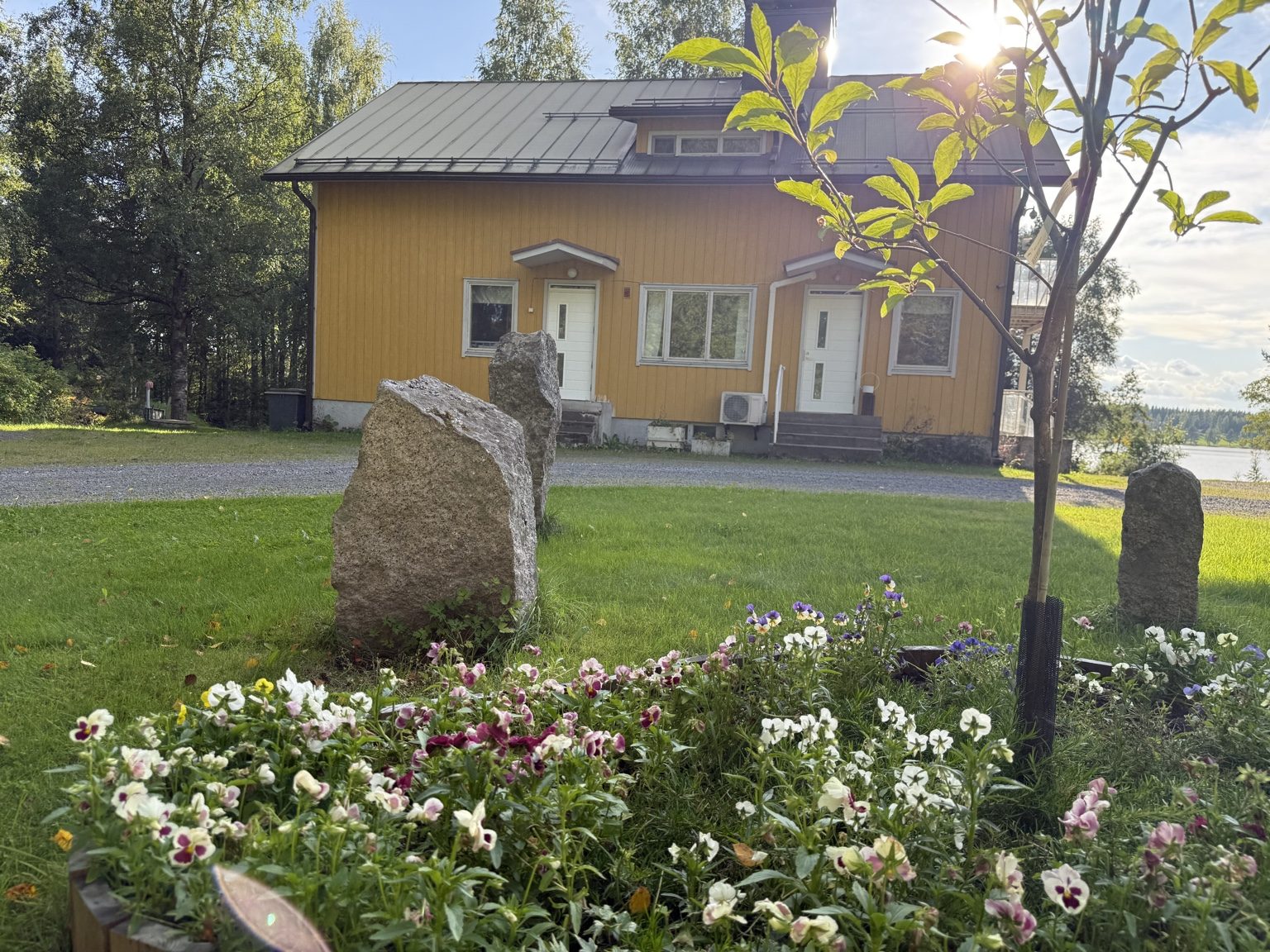 Asuntolan piha ja rakennus kesäisessä pihapiirissä